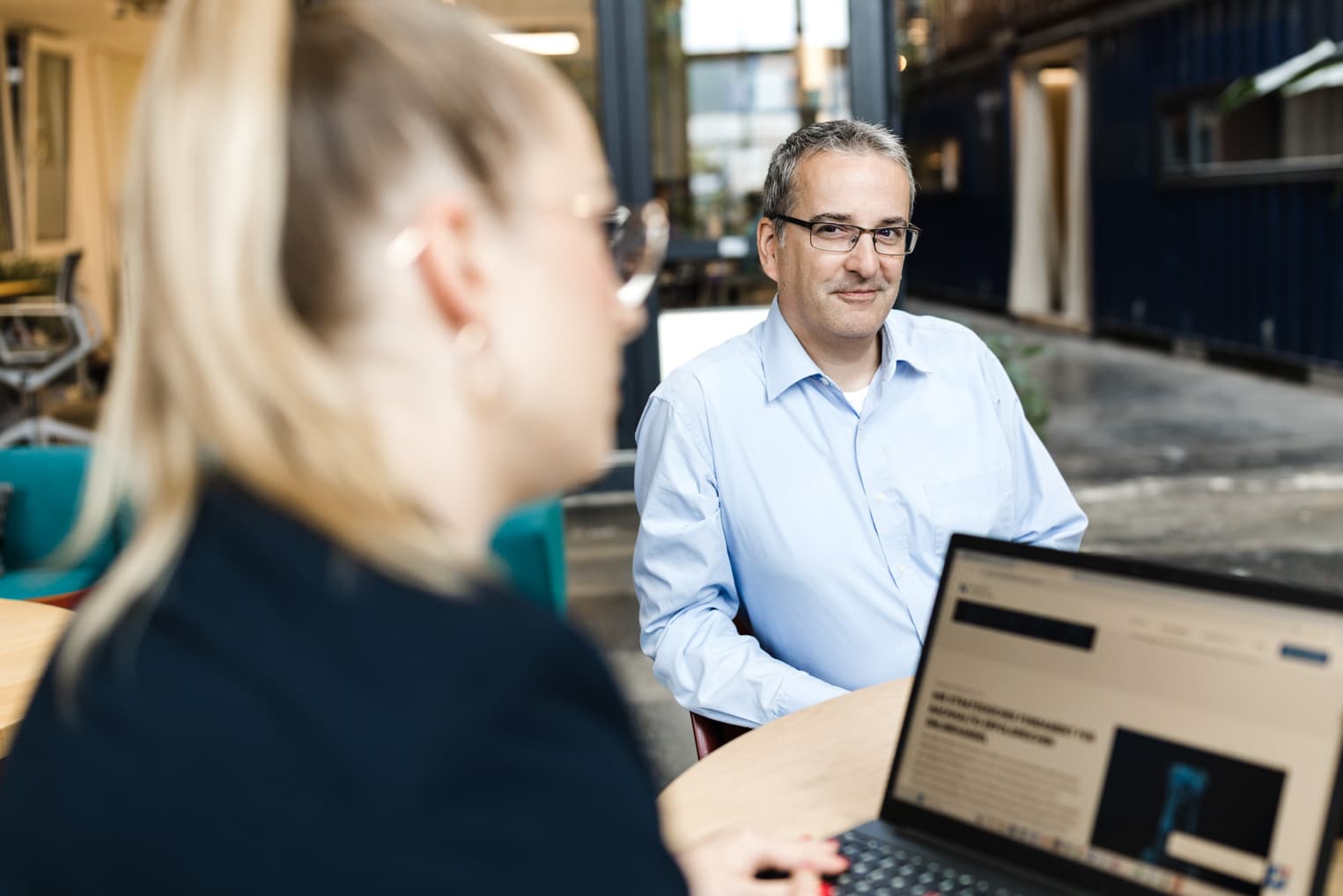 Business Portrait aus Freiburg mit Geschäftsmann im Fokus, Kollegin unscharf im Vordergrund
