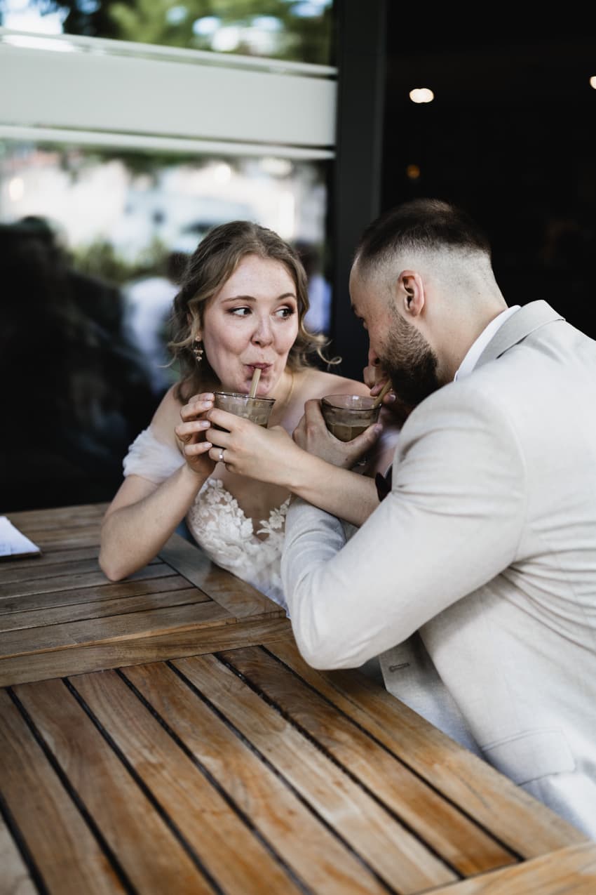 Brautpaar trinkt Kaffee mit Strohhalm natürliche Hochzeitsbilder Freiburg