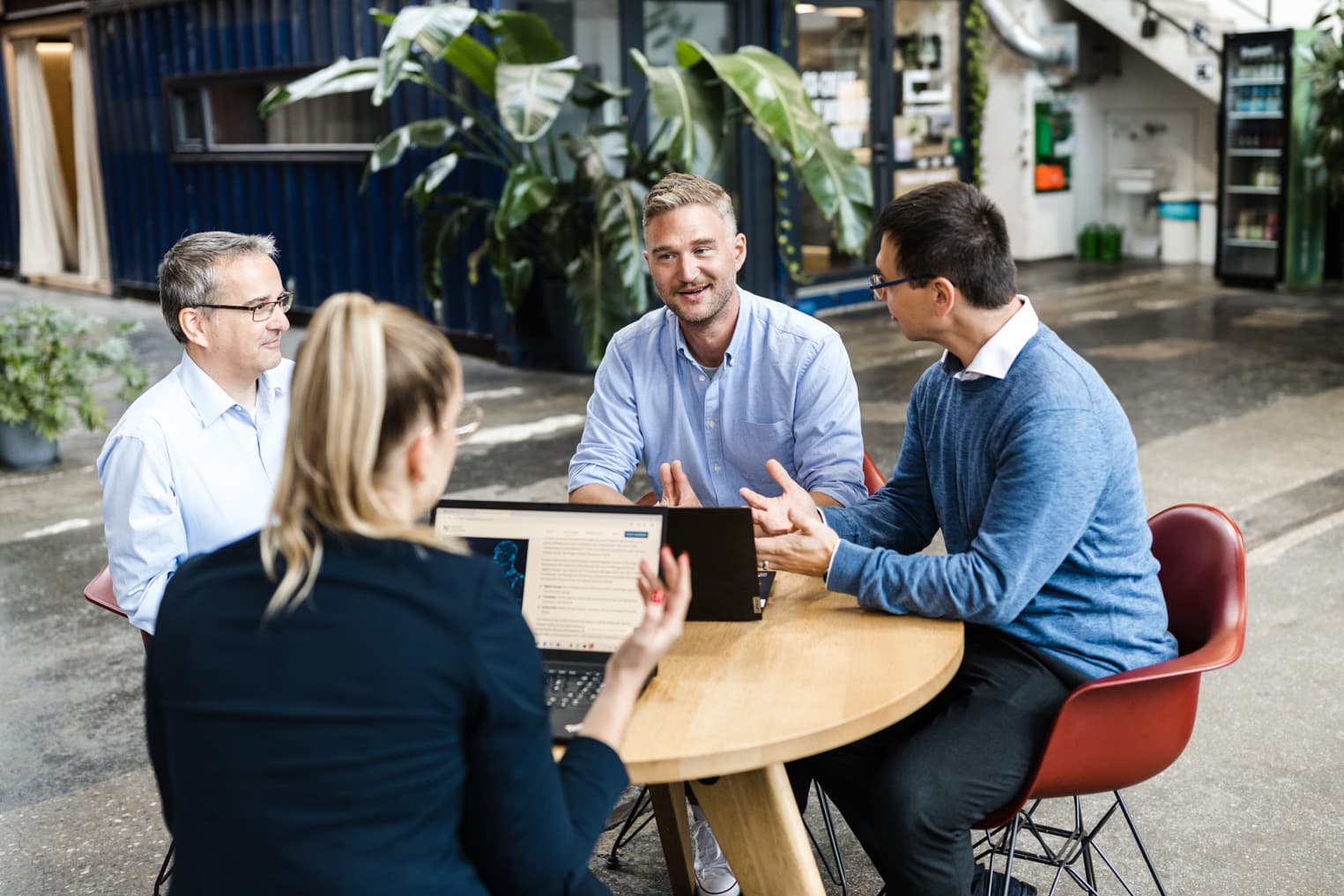 Unternehmensfotografie mit Gesprächsrunde von Mitarbeitenden an einem Tisch im Büro