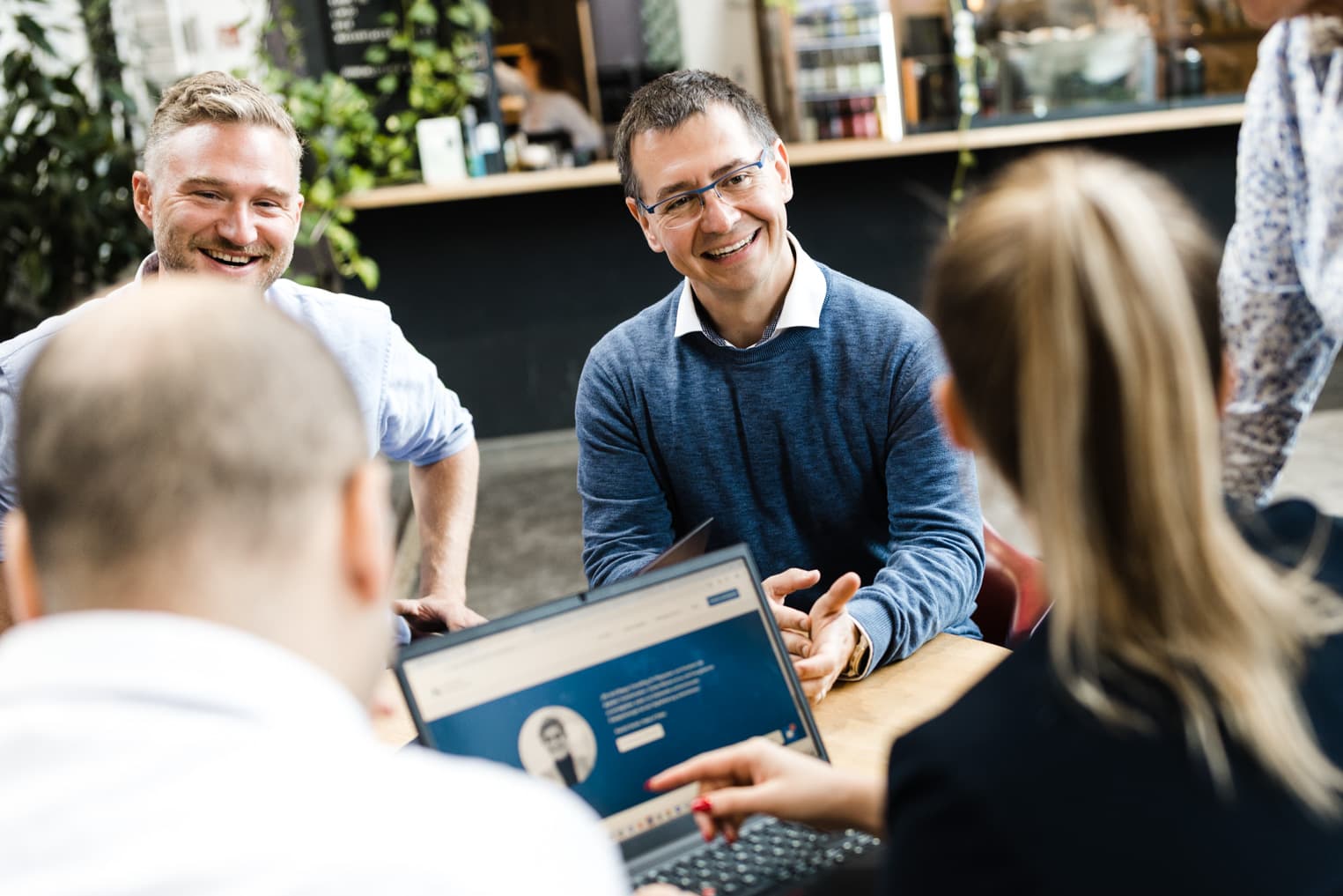 Business Fotografie eines Teams bei einer freundlichen Diskussionsrunde im Arbeitsalltag