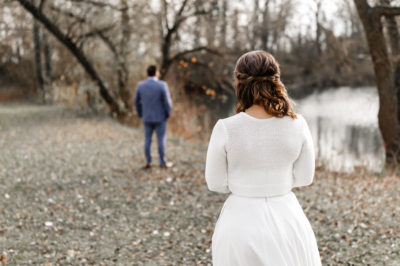 First Look am See, Braut von hinten zu sehen, Bräutigam wartet auf sie