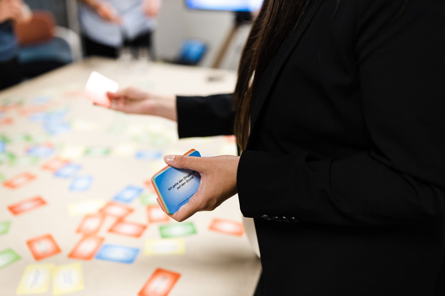 Detailaufnahme aus einer Schulung mit einer Hand, die Spielkarten hält, Business Fotografie für Unternehmen
