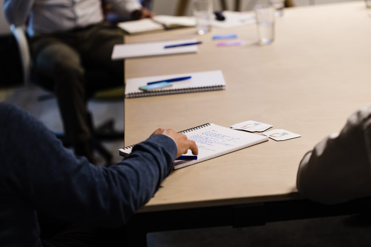 Moderne Business Fotografie mit Detailaufnahme eines Arbeitsplatzes, Hand mit Notizblock und Stift