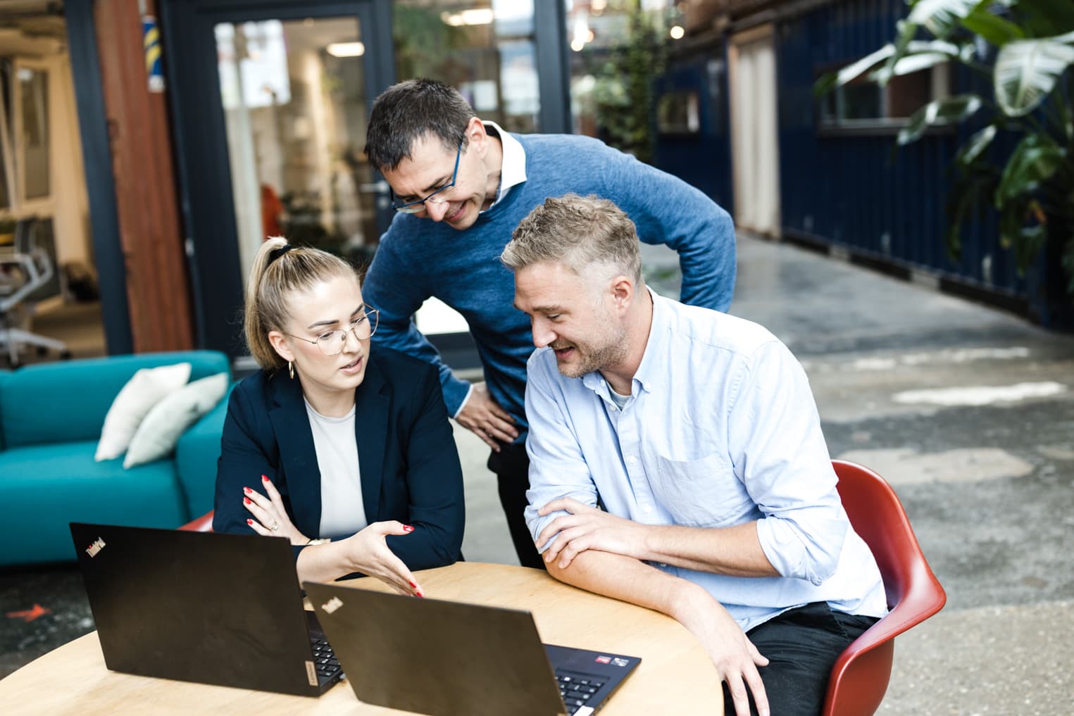 Business Fotografie im Büro mit drei Arbeitskollegen bei einer Besprechung am Laptop
