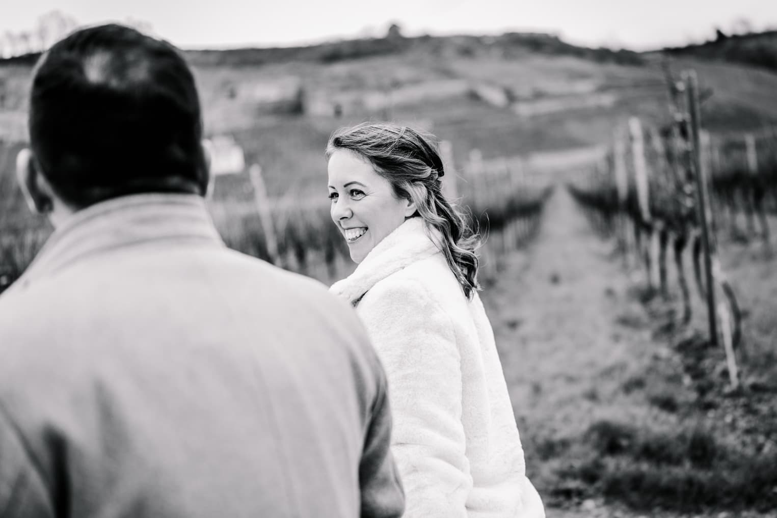 Brautpaar spaziert, Braut blickt zu Bräutigam, natürliche Hochzeitsfotografie