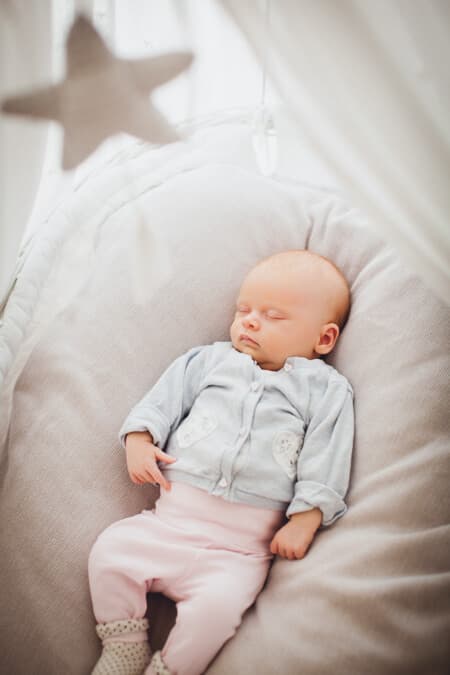 Baby liegt in Wiege mit Stern