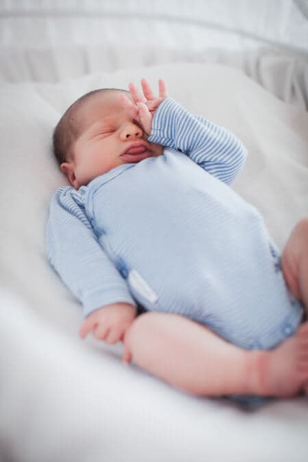 Baby reibt sich verschlafen die Augen