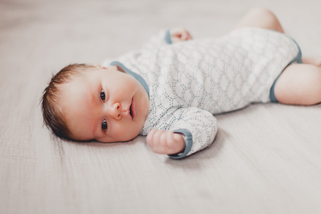 Babyjunge liegt auf einem Bett