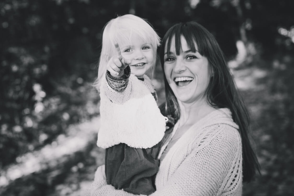 Mädchen auf dem Arm der Mutter zeigt auf etwas