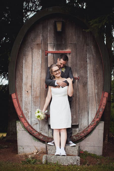 Brautpaar steht vor einem großen Fass