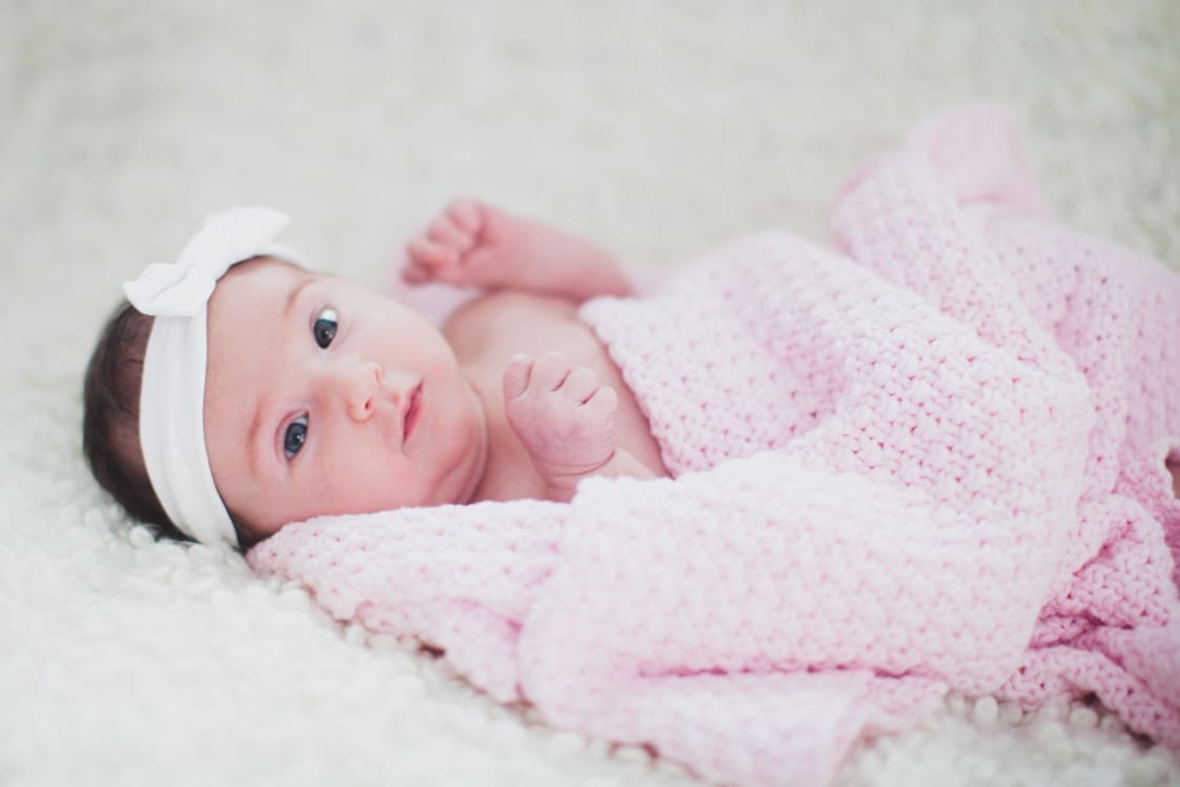 Baby in rosa Decke und schleife im Haar