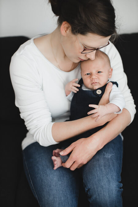Mutter hält ihr Baby umschlungen auf dem Arm