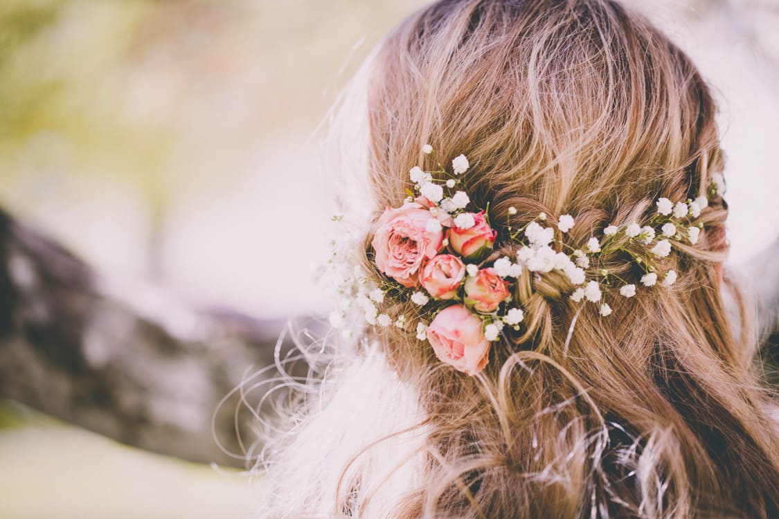 Nahaufnahme von der Frisur mit Blumenschmuck der Braut