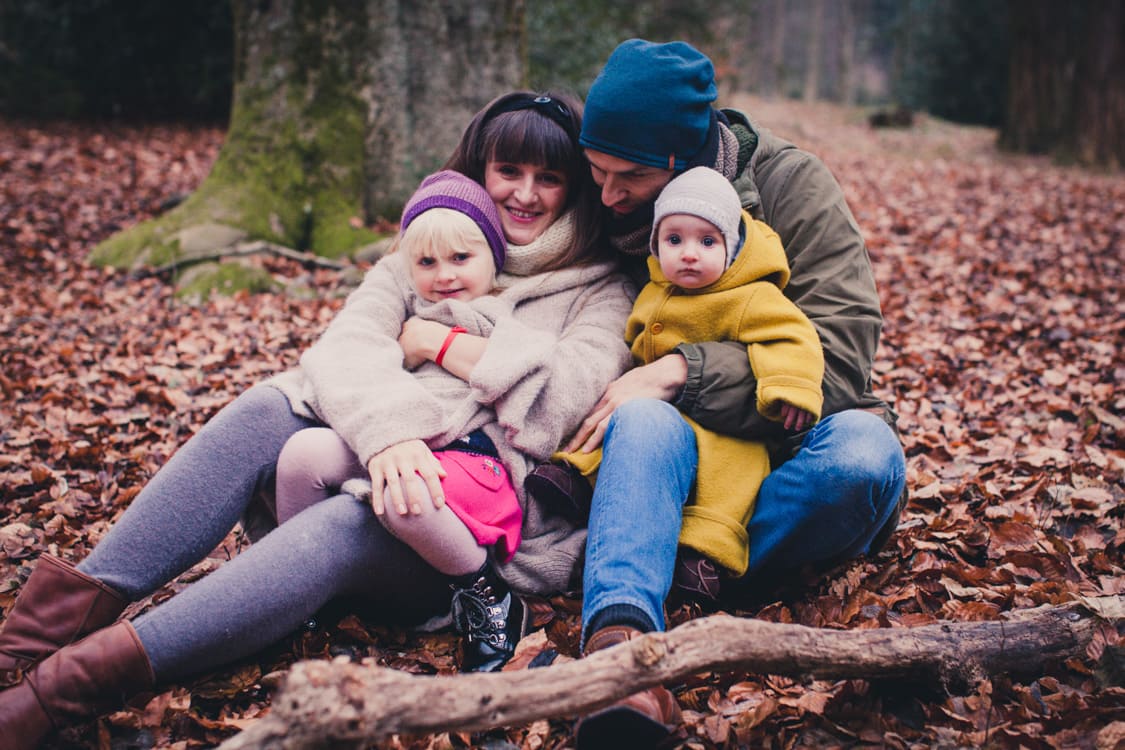 Familie sitzt auf dem Boden voller Blätter