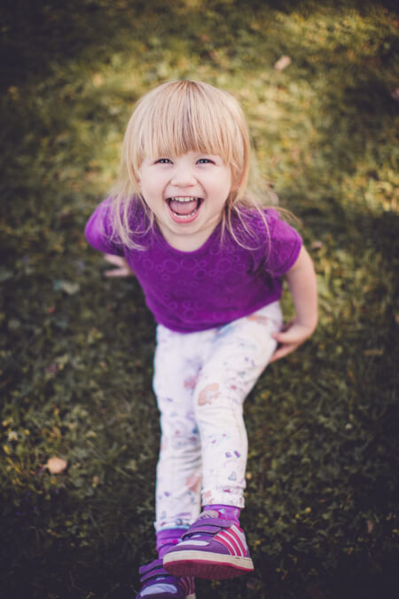 Lachendes Mädchen sitzt auf einer Wiese