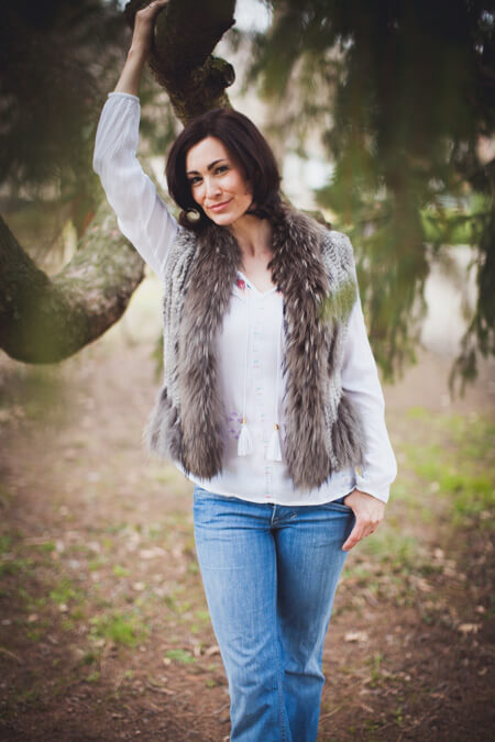 Frau mit Felljacke schaut verträumt