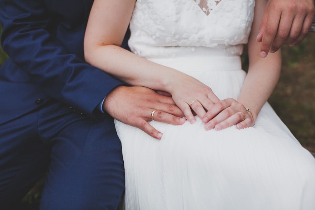 Nahaufnahme Hände von Brautpaar zusammen sitzend