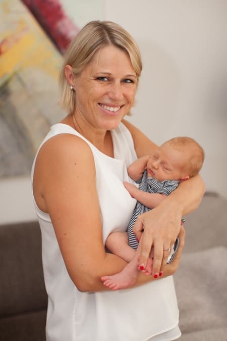 Glückliche Mutter mit ihrem Neugeborenen im Arm