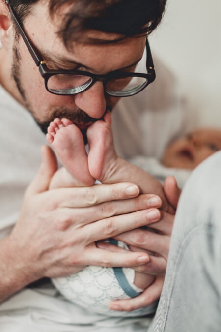 Vater küsst die Füße von seinem Baby