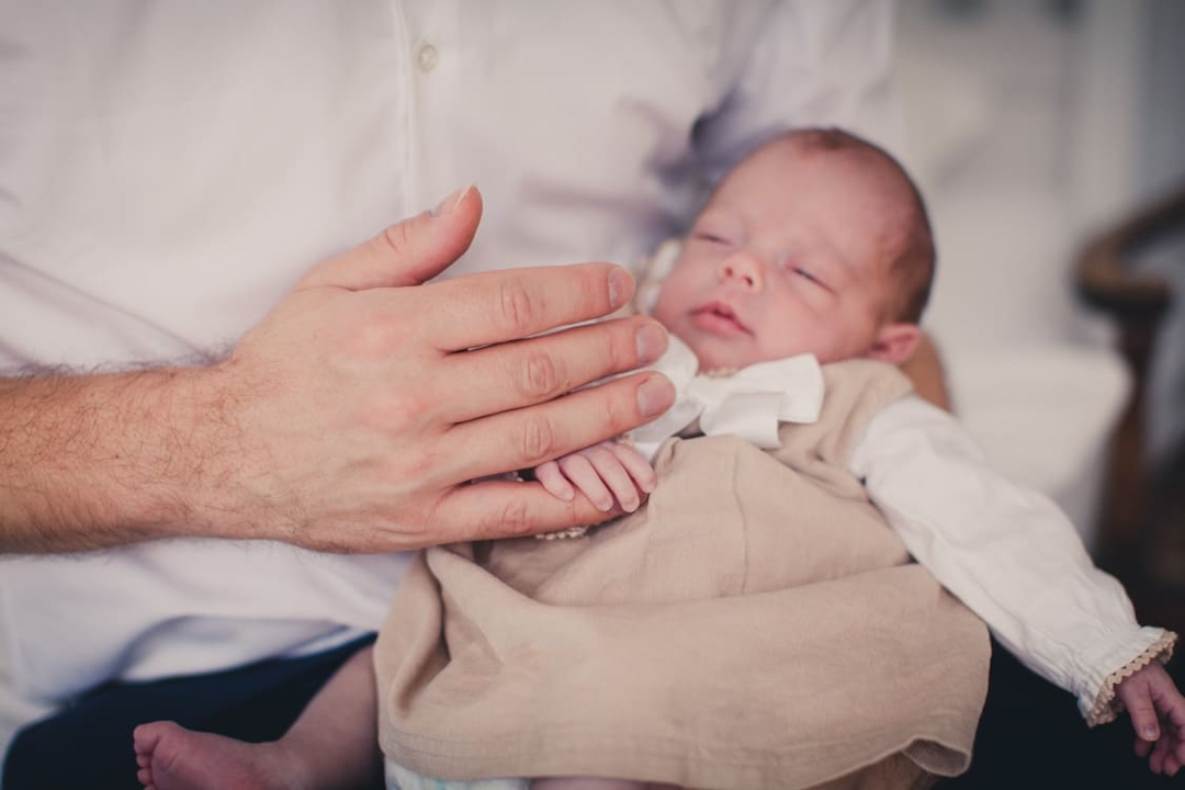 Nahaufnahme von Neugeborenem das den Finger vom Papa hält