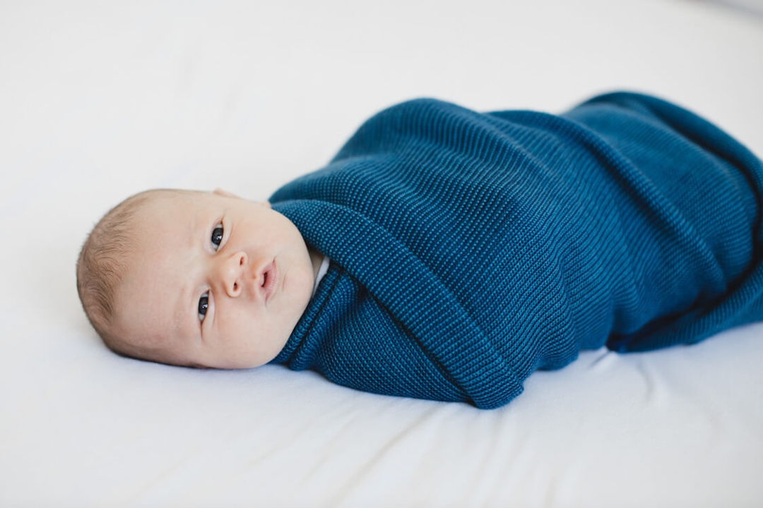 Baby eingepuckt im blaue Decke