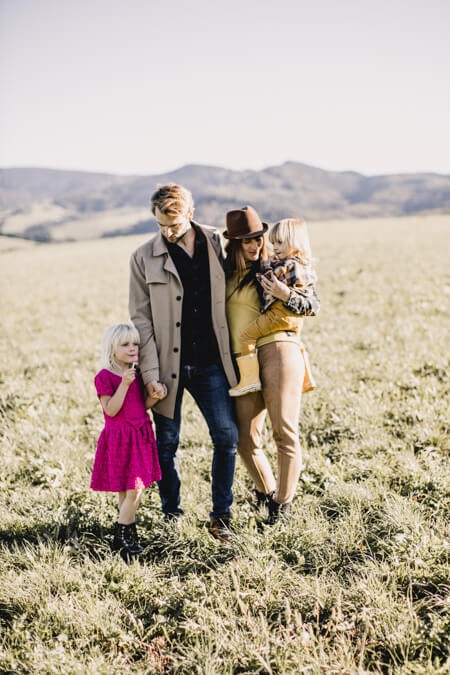 Familie mit zwei Kindern laufen über ein Feld