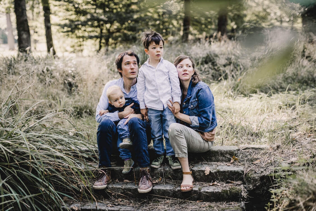 Familie sitzt auf einer Steintreppe in der Natur